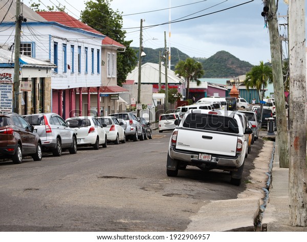 St\
John\'s, Antigua and Barbuda - November 24th 2019: Side Street with\
parked cars in St John\'s town centre retail area.\
