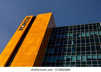 St. John's, Newfoundland, Canada -July 2022: The Upward View Of The Fortis Building. The Exterior Wall Of The Tall Building With Wood Style Metal Panels, Glass Windows With Shades, And A Sign, Fortis.