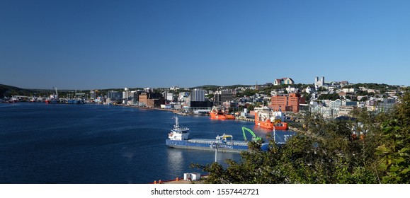 St. John's, Newfoundland, Canada - October 2019: Harbor View Of The Downtown Area Of St. John's With Large Offshore Oil Supply Vessels And Salmon Farming Feed Transport Boats Tied To The Dock.  