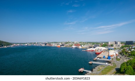 St. John's, Newfoundland, Canada - September 2021: Harbor View Of The Downtown Area Of St. John's With Large Offshore Oil Supply Vessels And Salmon Farming Feed Transport Boats Tied To The Dock.  