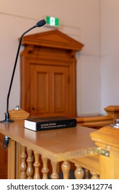 St. John's, NewfoundlandCanada - May 2019: The Witness Stand With A Bible In A Judicial Courtroom Prior To The Start Of A Legal Proceeding. The Room Was Empty Prior To The Arrival Of The Judge.