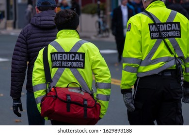 St. John's, Newfoundland/Canada-January 2020:Medical First Responders Walking Along A Road Wearing Black Wool Stocking Caps, Yellow Reflective Coats With Medical First Responder In Grey Letters.