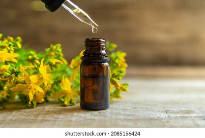 St. John's wort essential oil in a small bottle. Selective focus. Nature.
