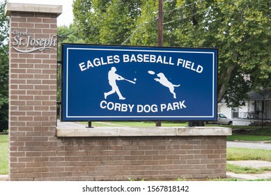 St. Joseph, MO / United States Of America - Sep 27th 2019 : Eagles Baseball Field, And Corby Dog Park Entrance Sign.  Blue Sign With White Text On A Brick Foundation.