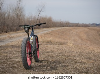 St. Joseph, MO / United States Of America - March 1st, 2020 : Mongoose Fat Bike On Side Of Dirt Trail.  Large Mountain Bike On Gravel Off Road Surface.  Long Trail In View.  No People.