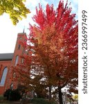 St. Louis Catholic Church, Louisville, Ohio, Red Brick Church with Steeple,  in October in Autumn, with Colorful Green, Yellow, Orange, and Red Maple Leaves, Fall Color Change, Spire