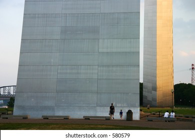 The St. Louis Gateway Arch In Missouri.  Photo Is Taken Level Showing The Near Side Very Large, And Far Side Very Small, With People In For Scale