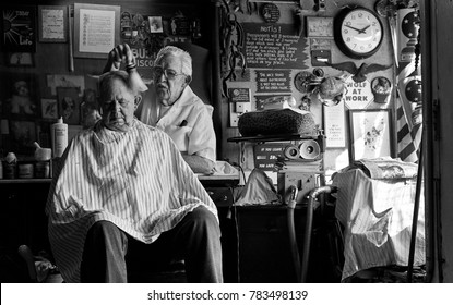 St Louis, Missouri, United States - Circa 2007 - Old Man Barber Cutting Customers Hair In Vintage Old-Fashioned Barbershop In Rundown City Neighborhood