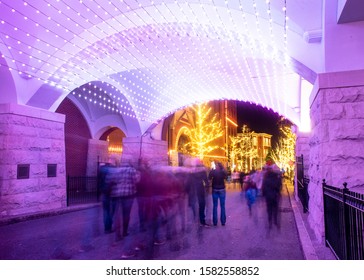 St Louis, Missouri, Usa, December 2019 -pedestriam Tunnel Glowing Brightly With Christmas Lights At Night At Anheuser Busch Brewery People Walking 