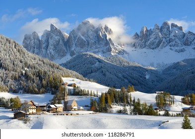 St. Magdalena or Santa Maddalena with its characteristic church in front of the Geisler or Odle dolomites mountain peaks in the Val di Funes (Villnosstal) in Italy in winter.