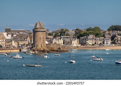 St. Malo, Brittany, France - July 8, 2022: Brown Stone La Tour Solidor In Front Of Saint-Servan Neighborhood Cityscape Under Blue Sky. White Sailing Yachts On Blue Water . Some Green Foliage