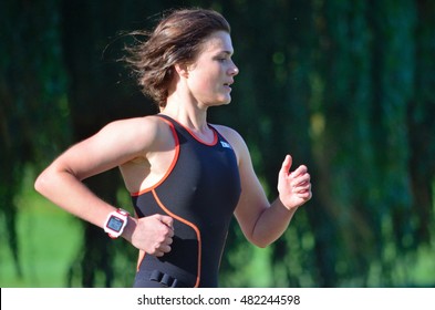 ST NEOTS, CAMBRIDGESHIRE, ENGLAND - SEPTEMBER 11, 2016: Close Up Of Female Triathlete Running In Black Skinsuit. 