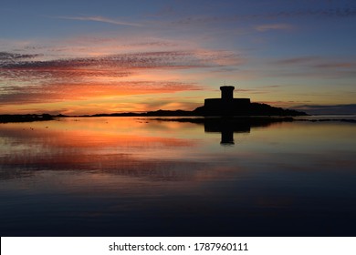 St Ouen's Bay, Jersey, U.K. Summer sunset with the 19th Rocco tower reflected in an ebbing tide.
