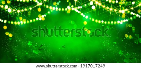 St. Patrick's Day abstract green background decorated with shamrock leaves. Patrick Day pub party celebrating. Abstract Border art design magic backdrop. Widescreen clovers on black with copy space