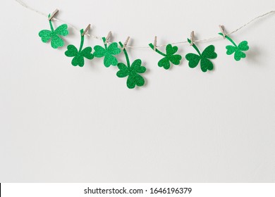 St. Patricks day background with Homemade glitter shamrocks garland. - Powered by Shutterstock