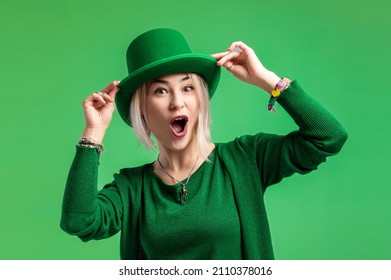 St. Patrick's Day. Beautiful smiling woman wearing green hat. Green background