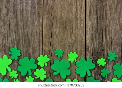 St Patricks Day Bottom Border Of Shamrocks Over A Rustic Wooden Background