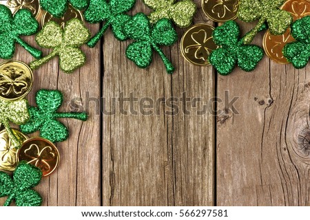 St Patricks Day corner border of shamrocks and gold coins over a rustic wood background