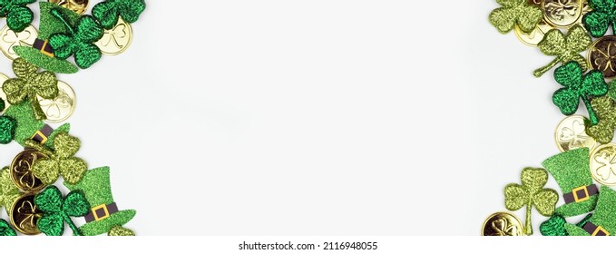 St Patricks Day double border against a white banner background. Top view with gold coins, shamrocks and leprechaun hats. Copy space.