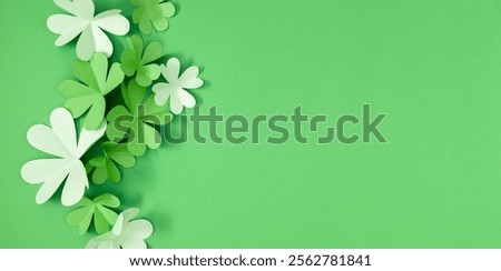 St Patrick's Day four leaf clover on green background. Patrick's Day composition, banner. Four-leaf clover paper art. Top view Flat lay