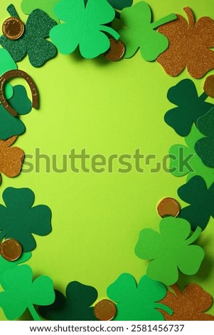 St. Patrick's Day frame. Flat lay composition with green shamrocks, gold coins, and a horseshoe on a green background