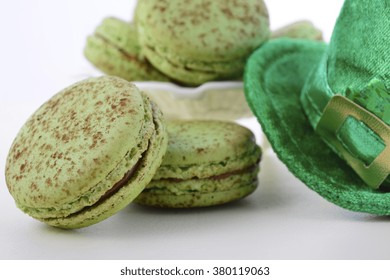 St Patricks Day green macarons with shamrock flags and leprechaun hat on white wood table background, closeup.   - Powered by Shutterstock