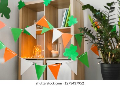 St Patricks Day, Holidays And Interior Concept - Close Up Of Bookcase Decorated By Festive Garland And Shamrock For Home Party