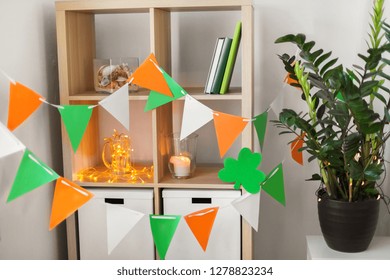 St Patricks Day, Holidays And Interior Concept - Close Up Of Bookcase Decorated By Festive Garland And Shamrock For Home Party