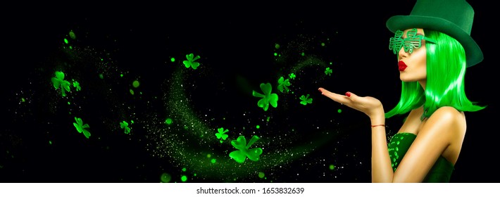 St. Patrick's Day leprechaun model girl pointing hand, holding product, isolated on black magic background, blowing shamrock leaves. Patrick Day pub party, celebrating. Border, Widescreen - Powered by Shutterstock