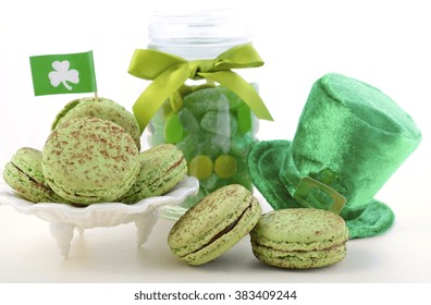 St Patricks Day party food with green macarons with shamrock flags, jar of candy and leprechaun hat on white wood table background.  - Powered by Shutterstock