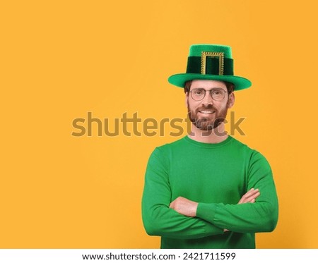 St. Patrick's day party. Man in green leprechaun hat on golden background. Space for text
