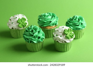 St. Patrick's day party. Tasty festively decorated cupcakes on green background - Powered by Shutterstock
