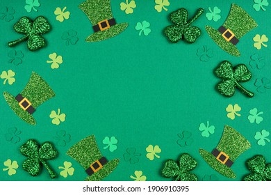 St Patricks Day shamrock and leprechaun hat frame. Above view over a green paper background with copy space.