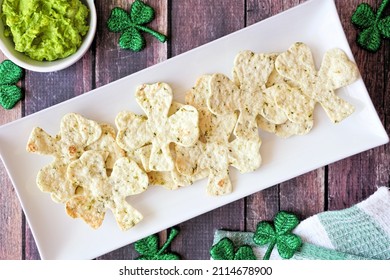 St Patricks Day Shamrock Nacho Chips With Guacamole. Overhead View On A Plate Against A Rustic Dark Wood Table Background.