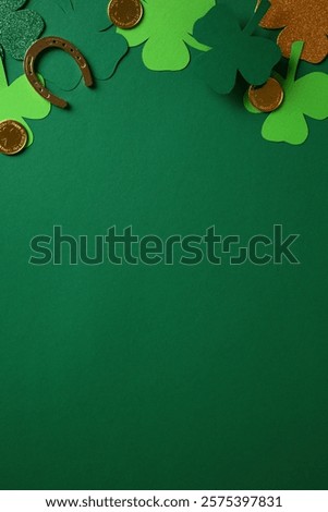 St. Patrick's Day vertical background with green and glittery shamrocks, gold coins, and a horseshoe on a dark green surface.