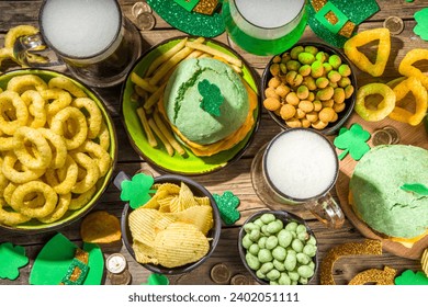 St Patrick`s holiday party invitation, bar menu background. Irish St Patrick`s day beer, ale glasses, snacks, appetizer, green burger, wooden bar table with shamrock, clover, coins, leprechaun hat - Powered by Shutterstock