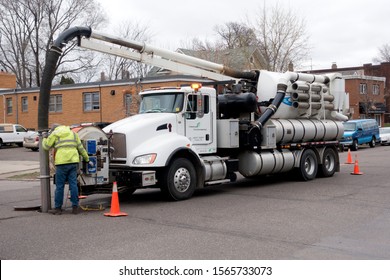ST PAUL, MINNESOTA / USA - APRIL 10, 2017: Worker sucking debris from sewer system with large vacuum truck. 