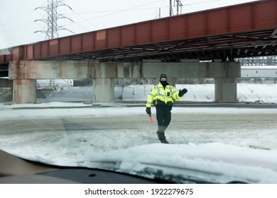 ST PAUL, MINNESOTA USA - DECEMBER 26, 2020: Masked Police Person Directing Traffic At The Starbucks Drive-thru During The Corona Pandemic.