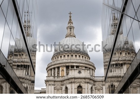 St Paul's Cathedral reflected in two glass buildings giving multiple reflections with a stormy sky