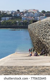 St Peter Port, Guernsey, Channel Islands; 23rd May 2015; Family Relaxing By Waters Edge Next To Harbour Wall