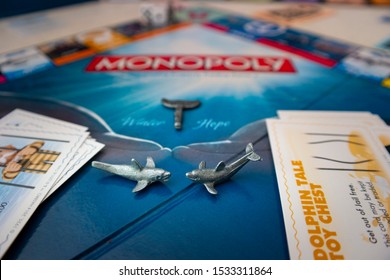 St. Petersburg, Florida / USA - August 2019: Winter And Hope Dolphin Tokens On The Clearwater Marine Aquarium Monopoly Game Board.