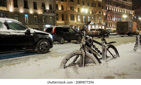 St Petersburg, Russia- 11-30-2021 bike in a snowdrift on the background of cars :after a snowfall on Nevsky Prospekt