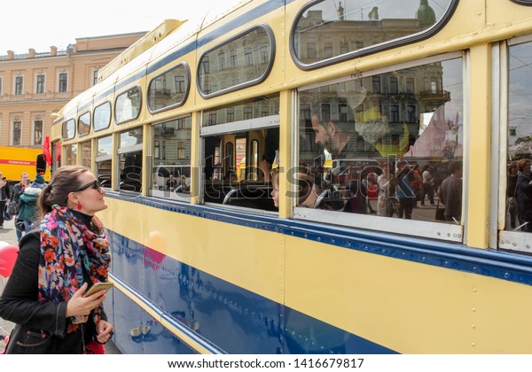 St. Petersburg, Russia - 25\
May, 2019.\
The girl at the open window of the trolley.\
The parade\
of retro transport and cars on the day of the city in St.\
Petersburg.