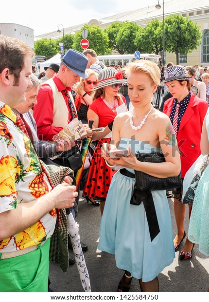 \
St. Petersburg, Russia - 25 May,\
2019.\
Women in the crowd.\
Show group in retro costumes on the day\
of the city in St.\
Petersburg.