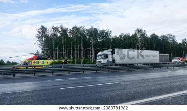 St.\
Petersburg, Russia - August 3 2019: Landing a medical helicopter on\
the highway after a car accident with wounded people and death.\
Aero-medical evacuation units or air\
ambulance