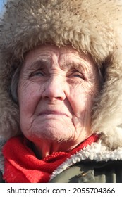 St. Petersburg, Russia - February 2, 2021. The Face Of An Old Woman In A Large Fur Hat Close-up. Severe Deep Facial Wrinkles