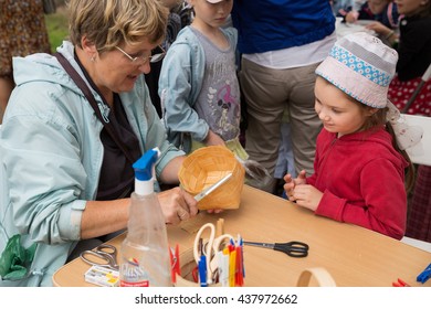 ST. PETERSBURG, RUSSIA - JULY 26, 2015: Unidentified Girl Learns To Weave Bast Basket On A City Fair. Master Class Teaching Children Folk Crafts Weaving A Basket