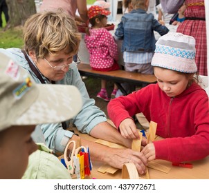 ST. PETERSBURG, RUSSIA - JULY 26, 2015: Unidentified Girl Learns To Weave Bast Basket On A City Fair. Master Class Teaching Children Folk Crafts Weaving A Basket