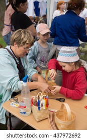 ST. PETERSBURG, RUSSIA - JULY 26, 2015: Unidentified Girl Learns To Weave Bast Basket On A City Fair. Master Class Teaching Children Folk Crafts Weaving A Basket