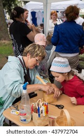 ST. PETERSBURG, RUSSIA - JULY 26, 2015: Unidentified Girl Learns To Weave Bast Basket On A City Fair. Master Class Teaching Children Folk Crafts Weaving A Basket